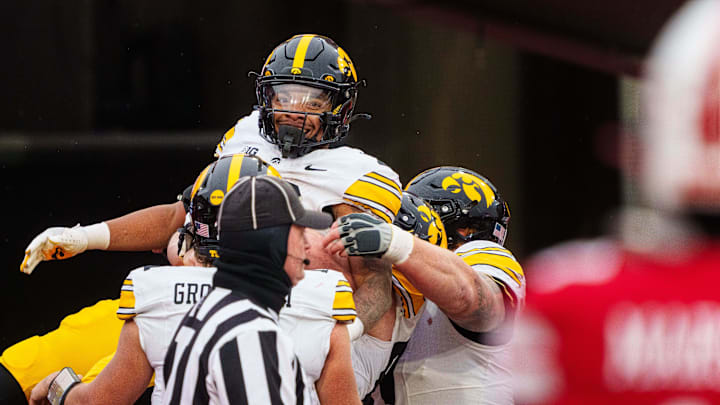 Nov 28, 2025; Lincoln, Nebraska, USA; Iowa Hawkeyes running back Kamari Moulton (28) is hoisted by teammates after scoring a touchdown against the Nebraska Cornhuskers during the fourth quarter at Memorial Stadium. Mandatory Credit: Dylan Widger-Imagn Images
