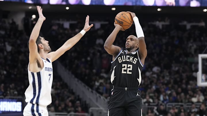 Feb 2, 2025; Milwaukee, Wisconsin, USA; Milwaukee Bucks forward Khris Middleton (22) puts up a shot against Memphis Grizzlies forward Santi Aldama (7) in the first half at Fiserv Forum. Mandatory Credit: Michael McLoone-Imagn Images