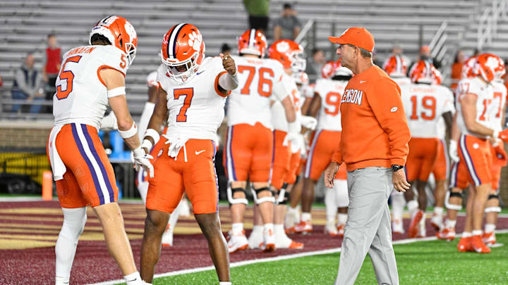 Oct 11, 2025; Chestnut Hill, Massachusetts, USA; Clemson Tigers head coach Dabo Swinney (l) talks to safety Ronan Hanafin (5) and safety Khalil Barnes (7) before a game against the Boston College Eagles at Alumni Stadium. Mandatory Credit: Eric Canha-Imagn Images