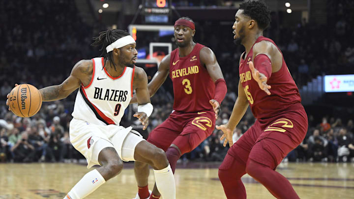 Nov 30, 2023; Cleveland, Ohio, USA; Cleveland Cavaliers guard Caris LeVert (3) and guard Donovan Mitchell (45) defend Portland Trail Blazers forward Jerami Grant (9) in the second quarter at Rocket Mortgage FieldHouse. Mandatory Credit: David Richard-Imagn Images