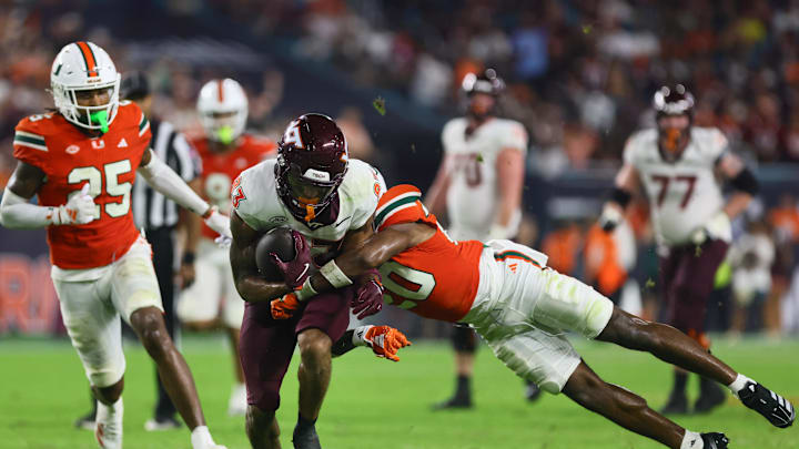 Sep 27, 2024; Miami Gardens, Florida, USA; Virginia Tech Hokies running back Bhayshul Tuten (33) runs with the football against Miami Hurricanes defensive back Zaquan Patterson (20) during the fourth quarter at Hard Rock Stadium. Mandatory Credit: Sam Navarro-Imagn Images Sep 27, 2024; Miami Gardens, Florida, USA; Virginia Tech Hokies running back Bhayshul Tuten (33) runs with the football against Miami Hurricanes defensive back Zaquan Patterson (20) during the fourth quarter at Hard Rock Stadium. Mandatory Credit: Sam Navarro-Imagn Images