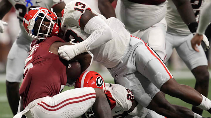 Georgia Bulldogs defensive lineman Mykel Williams (13) tackles Alabama Crimson Tide running back Roydell Williams. Georgia Bulldogs defensive lineman Mykel Williams (13) tackles Alabama Crimson Tide running back Roydell Williams.