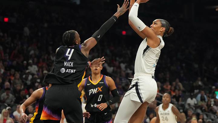 Aug 15, 2025; Phoenix, Arizona, USA; Las Vegas Aces center A'ja Wilson (22) shoots over Phoenix Mercury forward Natasha Mack (4) in the first half at Footprint Center. Mandatory Credit: Rick Scuteri-Imagn Images