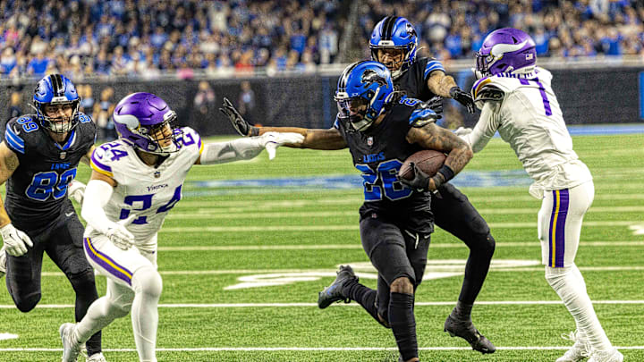 Jan 5, 2025; Detroit, Michigan, USA; Detroit Lions running back Jahmyr Gibbs (26) pushes off of Minnesota Vikings safety Camryn Bynum (24) and scores a touchdown during the second half at Ford Field. Mandatory Credit: David Reginek-Imagn Images
