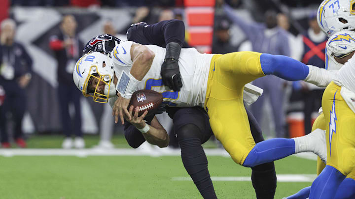 Jan 11, 2025; Houston, Texas, USA; Houston Texans defensive end Denico Autry (96) sacks Los Angeles Chargers quarterback Justin Herbert (10) during the game in an AFC wild card game at NRG Stadium. Mandatory Credit: Troy Taormina-Imagn Images