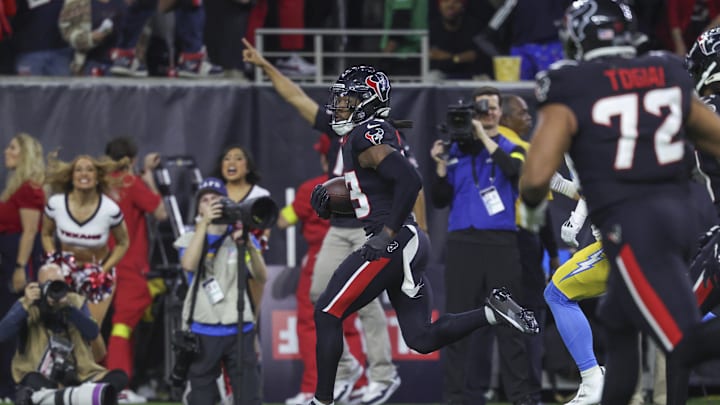 Jan 11, 2025; Houston, Texas, USA; Houston Texans safety Eric Murray (23) returns an interception for a touchdown during the game against the Los Angeles Chargers in an AFC wild card game at NRG Stadium. Mandatory Credit: Troy Taormina-Imagn Images