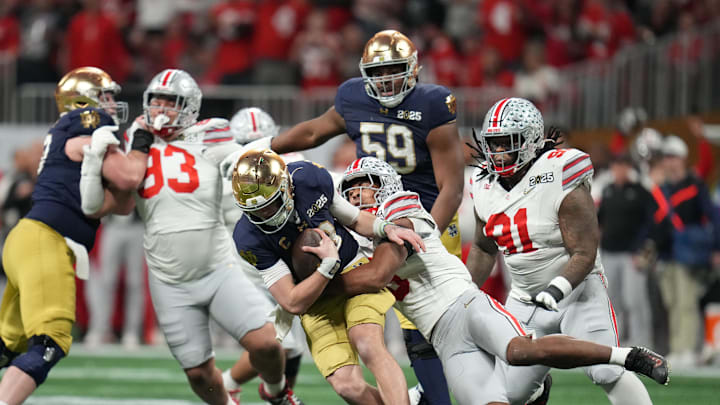 Jan 20, 2025; Atlanta, GA, USA; Notre Dame Fighting Irish quarterback Riley Leonard (13) is sacked by Ohio State Buckeyes safety Sonny Styles (6) in the second half in the CFP National Championship college football game at Mercedes-Benz Stadium. Mandatory Credit: Kirby Lee-Imagn Images