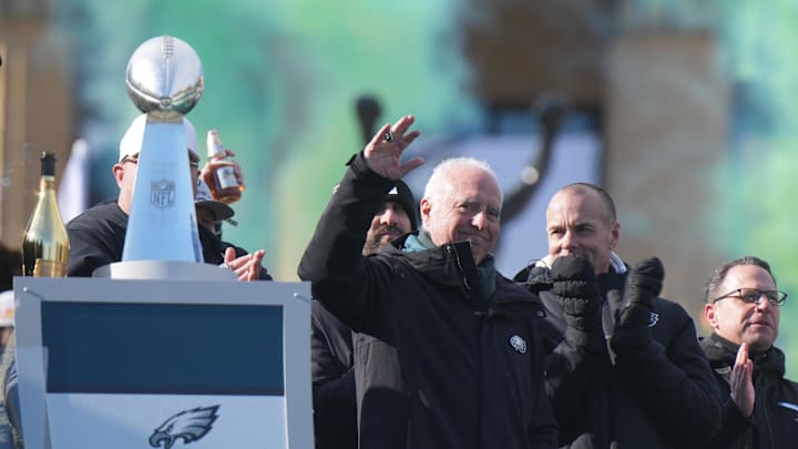 Philadelphia Eagles owner Jeffrey Lurie waves to the crowd next to the Vince Lombardi Trophy during the Super Bowl LIX championship parade.