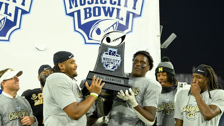 Dec 30, 2024; Nashville, TN, USA; Missouri Tigers wide receiver Theo Wease Jr. (1) and defensive end Johnny Walker Jr. (15) hoist the trophy up against the Iowa Hawkeyes during the trophy presentation at Nissan Stadium. Mandatory Credit: Steve Roberts-Imagn Images Dec 30, 2024; Nashville, TN, USA; Missouri Tigers wide receiver Theo Wease Jr. (1) and defensive end Johnny Walker Jr. (15) hoist the trophy up against the Iowa Hawkeyes during the trophy presentation at Nissan Stadium. Mandatory Credit: Steve Roberts-Imagn Images