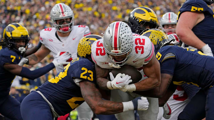 Nov. 25, 2023; Ann Arbor, Mi., USA;
Ohio State Buckeyes running back TreVeyon Henderson (32) is tackled by Michigan Wolverines linebacker Michael Barrett (23) and Michigan Wolverines defensive back Rod Moore (9) as he drives into the end zone for a touchdown during the second half of Saturday's NCAA Division I football game against the Michigan Wolverines at Michigan Stadium.