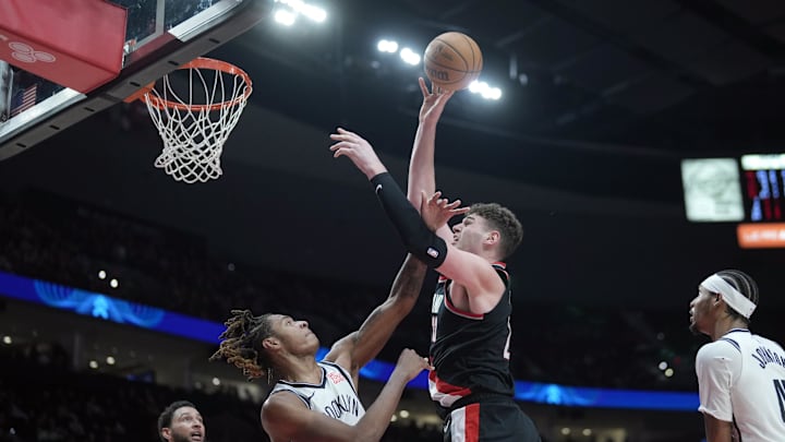 Jan 14, 2025; Portland, Oregon, USA; Portland Trail Blazers center Donovan Clingan (23) shoots the ball over Brooklyn Nets forward Noah Clowney (21) during the second half at Moda Center. Mandatory Credit: Soobum Im-Imagn Images