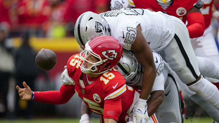 Dec 25, 2023; Kansas City, Missouri, USA; Kansas City Chiefs quarterback Patrick Mahomes (15) recovers his fumble as he is hit by Las Vegas Raiders defensive tackle Adam Butler (69) and defensive end Malcolm Koonce (51) during the first half at GEHA Field at Arrowhead Stadium. Mandatory Credit: Jay Biggerstaff-Imagn Images