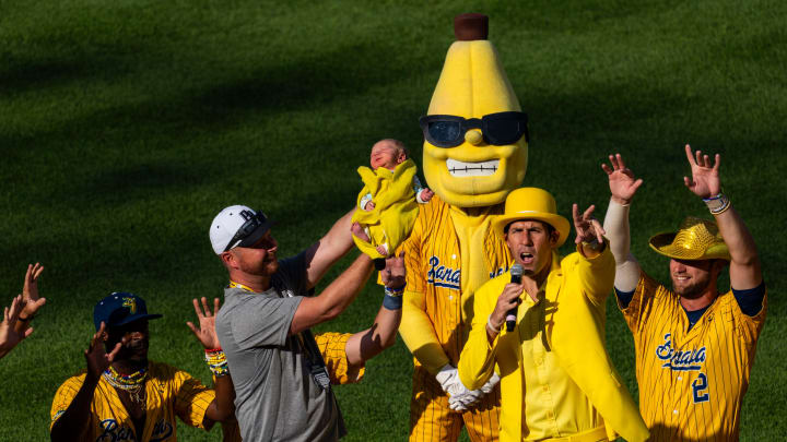 The Savannah Bananas hold up a baby Thursday, June 27, 2024, during a Savannah Bananas World Tour show at Victory Field in Indianapolis.