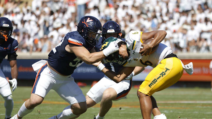 Sep 13, 2025; Charlottesville, Virginia, USA; William & Mary Tribe quarterback Tyler Hughes (6) is sacked by Virginia Cavaliers defensive lineman Daniel Rickert (52) ball against the Virginia Cavaliers during the second quarter at Scott Stadium. Sep 13, 2025; Charlottesville, Virginia, USA; William & Mary Tribe quarterback Tyler Hughes (6) is sacked by Virginia Cavaliers defensive lineman Daniel Rickert (52) ball against the Virginia Cavaliers during the second quarter at Scott Stadium.