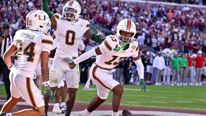 Dec 20, 2025; College Station, TX, USA; Miami Hurricanes defensive back Ethan O'Connor (24) and defensive back Keionte Scott (0) and defensive back Bryce Fitzgerald (13) celebrate after Fitzgerald intercepts a Texas A&M Aggies pass in the end zone during the game between the Aggies and the Hurricanes at Kyle Field. Mandatory Credit: Jerome Miron-Imagn Images
