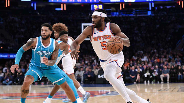 Oct 15, 2024; New York, New York, USA; New York Knicks forward Precious Achiuwa (5) drives to the basket while being defended by Charlotte Hornets forward Miles Bridges (0) during the first half at Madison Square Garden. Mandatory Credit: John Jones-Imagn Images
