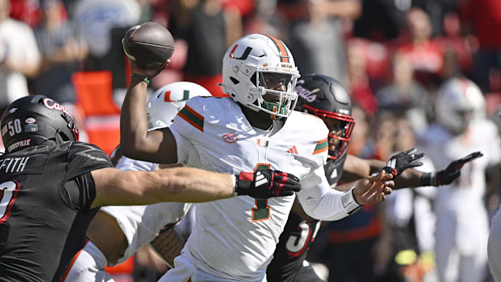 Oct 19, 2024; Louisville, Kentucky, USA; Miami Hurricanes quarterback Cam Ward (1) looks to pass under the pressure of Louisville Cardinals defensive lineman Thor Griffith (50) during the second half at L&N Federal Credit Union Stadium. Miami defeated Louisville 52-45. Mandatory Credit: Jamie Rhodes-Imagn Images Oct 19, 2024; Louisville, Kentucky, USA; Miami Hurricanes quarterback Cam Ward (1) looks to pass under the pressure of Louisville Cardinals defensive lineman Thor Griffith (50) during the second half at L&N Federal Credit Union Stadium. Miami defeated Louisville 52-45. Mandatory Credit: Jamie Rhodes-Imagn Images
