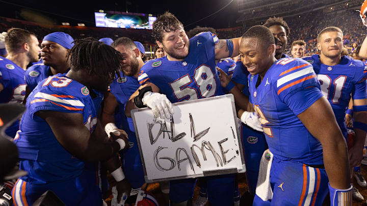 Florida Gators offensive lineman Austin Barber (58) pulls in Florida Gators quarterback DJ Lagway (2) as the Gators celebrated at Ben Hill Griffin Stadium in Gainesville, FL on Saturday, November 16, 2024. The Gators defeated the Tigers 27-16. [Doug Engle/Gainesville Sun]