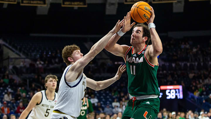 Jan 13, 2026; South Bend, Indiana, USA; Miami (FL) Hurricanes center Salih Altuntas (11) drives to the basket as Miami (FL) Hurricanes forward Shelton Henderson (7) defends defends during the second half at Purcell Pavilion at the Joyce Center. Mandatory Credit: Michael Caterina-Imagn Images