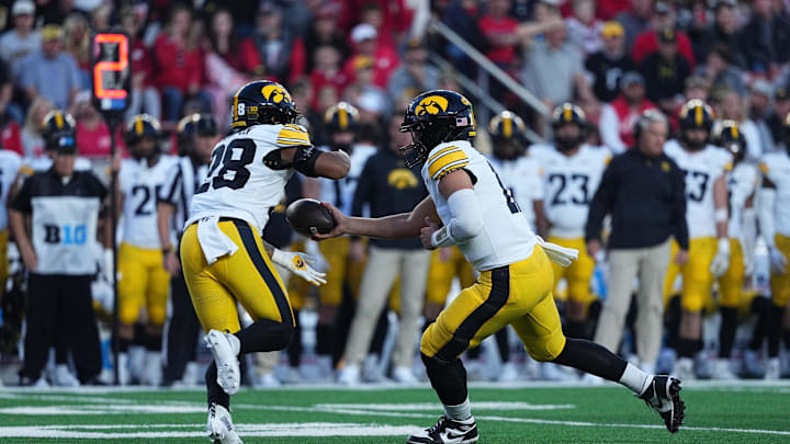Oct 11, 2025; Madison, Wisconsin, USA; Iowa Hawkeyes quarterback Mark Gronowski (11) hands the ball off to running back Kamari Moulton (28) in the first quarter against the Wisconsin Badgers at Camp Randall Stadium. Mandatory Credit: Ross Harried-Imagn Images