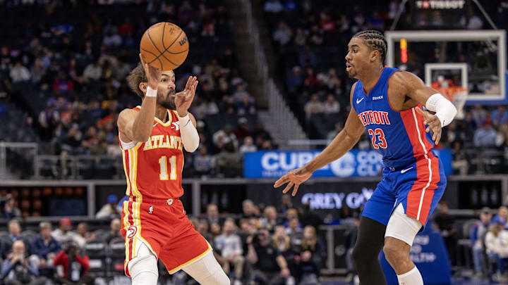 Nov 8, 2024; Detroit, Michigan, USA; Atlanta Hawks guard Trae Young (11) passes the ball as Detroit Pistons guard Jaden Ivey (23) defends during the in the first half at Little Caesars Arena. Mandatory Credit: David Reginek-Imagn Images