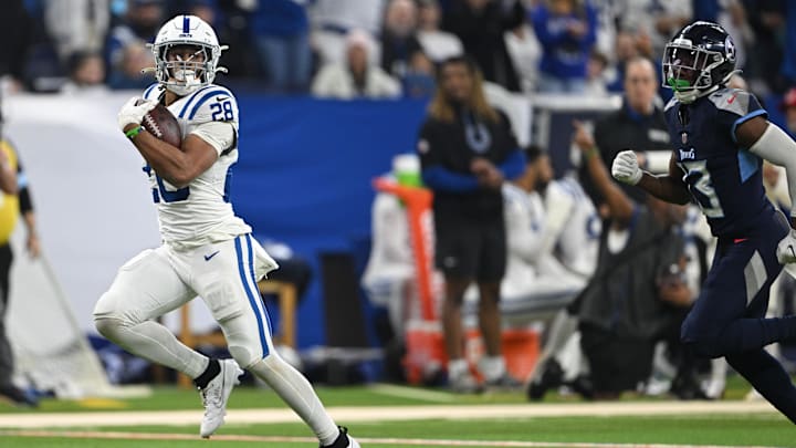 Dec 22, 2024; Indianapolis, Indiana, USA; Indianapolis Colts running back Jonathan Taylor (28) runs the ball past Tennessee Titans cornerback Chidobe Awuzie (13) for a touchdown during the second quarter at Lucas Oil Stadium. Mandatory Credit: Marc Lebryk-Imagn Images