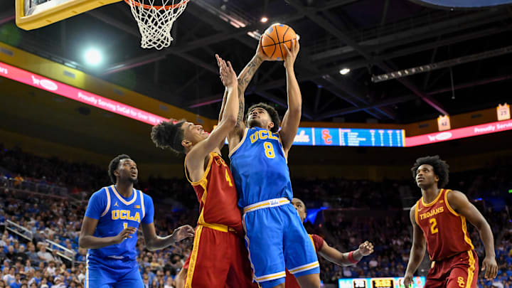 Feb 24, 2026; Los Angeles, California, USA; UCLA Bruins guard Eric Freeny (8) shoots over Southern California Trojans guard Chad Baker-Mazara (4) during the second half at Pauley Pavilion presented by Wescom Financial. Mandatory Credit: Robert Hanashiro-Imagn Images