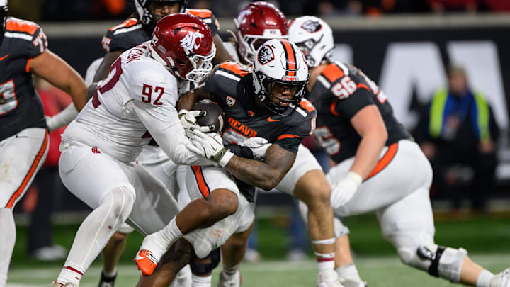 Nov 1, 2025; Corvallis, Oregon, USA; Oregon State Beavers running back Anthony Hankerson (0) runs the ball late in the 4th quarter against Washington State Cougars defensive lineman Darrion Dalton (92) at Reser Stadium. Mandatory Credit: Craig Strobeck-Imagn Images