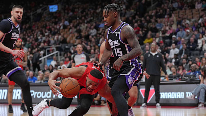 Mar 20, 2024; Toronto, Ontario, CAN; Toronto Raptors forward Bruce Brown (11) controls the ball as Sacramento Kings guard Davion Mitchell (15) tries to defend during the fourth quarter at Scotiabank Arena. Mandatory Credit: Nick Turchiaro-Imagn Images