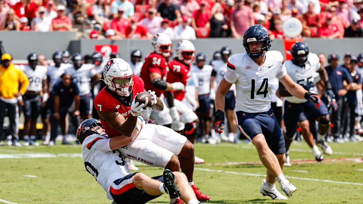 Sep 6, 2025; Raleigh, North Carolina, USA; Virginia Cavaliers safety Ethan Minter (30) tackles North Carolina State Wolfpack tight end Justin Joly (7) during the first half of the game at Carter-Finley Stadium. Mandatory Credit: Jaylynn Nash-Imagn Images