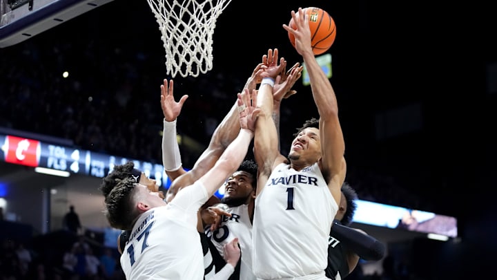 Xavier Musketeers forward Lazar Djokovic (17), Cincinnati Bearcats forward Ody Oguama (33), Xavier Musketeers guard Dayvion McKnight (20), Xavier Musketeers guard Desmond Claude (1) and Cincinnati Bearcats forward John Newman III (15) compete for a rebound in the first half of the 91st Crosstown Shootout basketball game between the Cincinnati Bearcats and the Xavier Musketeers, Saturday, Dec. 9, 2023, at Cintas Center in Cincinnati. Xavier Musketeers forward Lazar Djokovic (17), Cincinnati Bearcats forward Ody Oguama (33), Xavier Musketeers guard Dayvion McKnight (20), Xavier Musketeers guard Desmond Claude (1) and Cincinnati Bearcats forward John Newman III (15) compete for a rebound in the first half of the 91st Crosstown Shootout basketball game between the Cincinnati Bearcats and the Xavier Musketeers, Saturday, Dec. 9, 2023, at Cintas Center in Cincinnati.