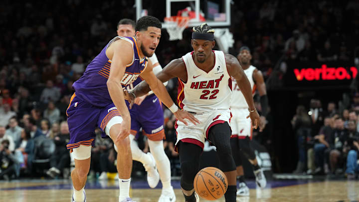 Nov 6, 2024; Phoenix, Arizona, USA; Phoenix Suns guard Devin Booker (1) and Miami Heat forward Jimmy Butler (22) chase a loose ball during the second half at Footprint Center. Mandatory Credit: Joe Camporeale-Imagn Images