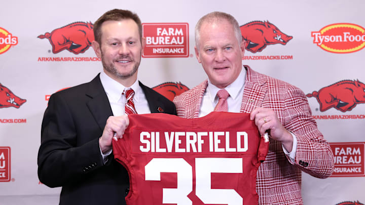 Dec 4, 2025; Fayetteville, AR, USA; Arkansas Razorbacks head coach Ryan Silverfield during his introductory press conference and vice chancellor and director of athletics Hunter Yurachek pose with a jersey with the number 35 signifying the 35th Arkansas head coach at Frank Broyles Center. Mandatory  Credit: Nelson Chenault-Imagn Images