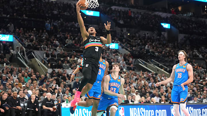 Feb 4, 2026; San Antonio, Texas, USA; San Antonio Spurs forward Keldon Johnson (3) drives to the basket past Oklahoma City Thunder guard Brooks Barnhizer (23) during the first half at Frost Bank Center. Mandatory Credit: Scott Wachter-Imagn Images