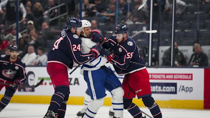 Oct 22, 2024; Columbus, Ohio, USA;  Toronto Maple Leafs right wing Ryan Reaves, middle, scrums with Columbus Blue Jackets right wing Mathieu Olivier, left, and defenseman David Jiricek, right, during the third period at Nationwide Arena. Mandatory Credit: Aaron Doster-Imagn Images