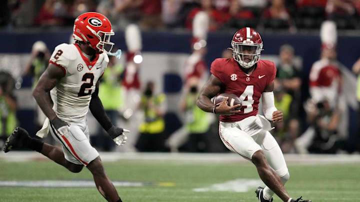 Dec 2, 2023; Atlanta, GA, USA; Alabama Crimson Tide quarterback Jalen Milroe (4) rushes the ball against Georgia Bulldogs linebacker Smael Mondon Jr. (2) during the first half in the SEC Championship game at Mercedes-Benz Stadium. Mandatory Credit: Dale Zanine-Imagn Images