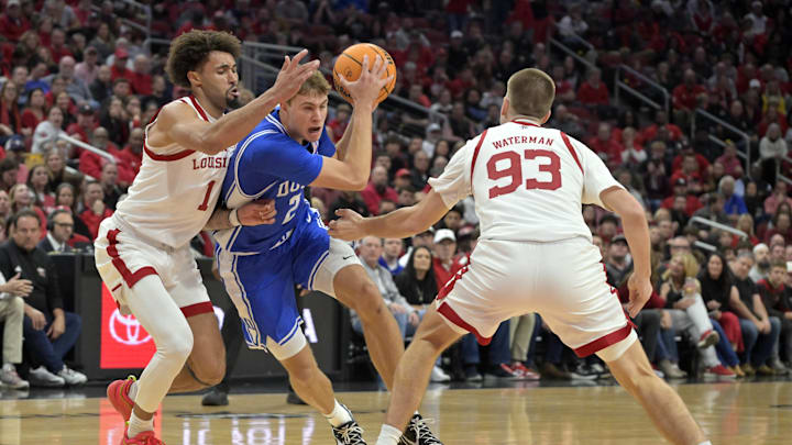 Dec 8, 2024; Louisville, Kentucky, USA;  Duke Blue Devils guard Cooper Flagg (2) drives to the basket against Louisville Cardinals guard J'Vonne Hadley (1) and forward Noah Waterman (93) during the first half at KFC Yum! Center. Mandatory Credit: Jamie Rhodes-Imagn Images