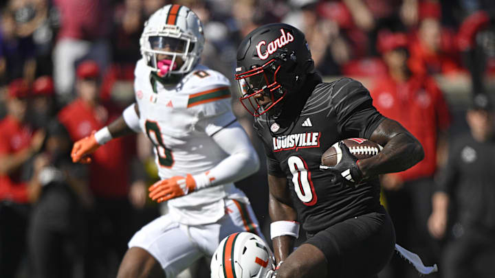 Oct 19, 2024; Louisville, Kentucky, USA; Louisville Cardinals wide receiver Chris Bell (0) runs the ball against the Miami Hurricanes during the first half at L&N Federal Credit Union Stadium. Mandatory Credit: Jamie Rhodes-Imagn Images