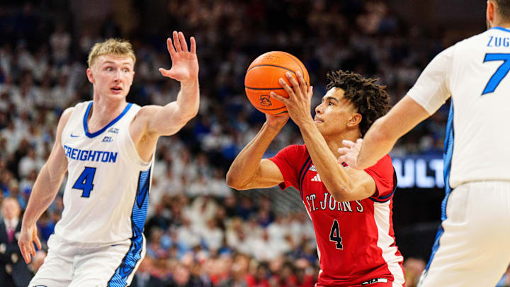 Jan 10, 2026; Omaha, Nebraska, USA; St. John's basketball guard Oziyah Sellers (4) shoots the ball against Creighton Bluejays guard Josh Dix (4) and guard Fedor Žugić (7) during the first half at CHI Health Center Omaha.