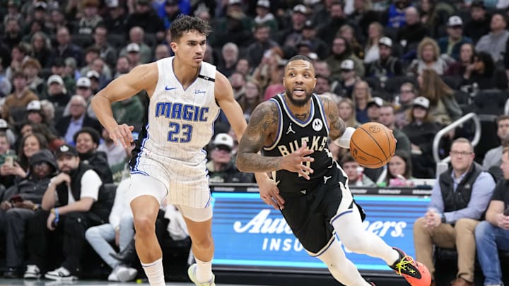 Jan 15, 2025; Milwaukee, Wisconsin, USA;  Milwaukee Bucks guard Damian Lillard (0) drives for the basket in front of Orlando Magic forward Tristan Da Silva (23) during the second quarter at Fiserv Forum. Mandatory Credit: Jeff Hanisch-Imagn Images