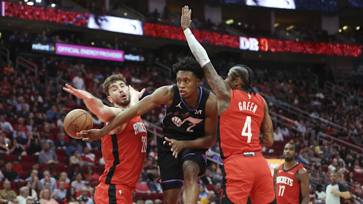 Utah Jazz guard Collin Sexton passes the ball around Houston Rockets center Alperen Sengun.