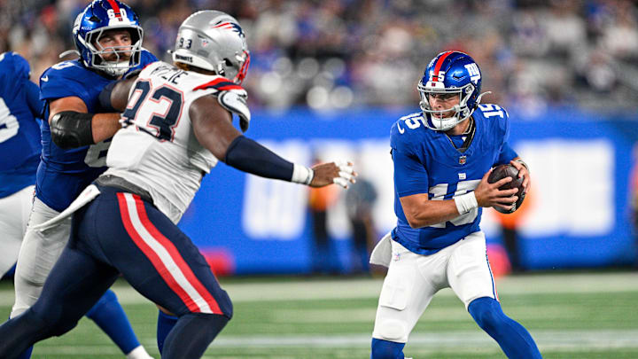 Aug 21, 2025; East Rutherford, New Jersey, USA; New York Giants quarterback Tommy DeVito (15) runs with the ball chased by New England Patriots defensive tackle Jahvaree Ritzie (93) during the third quarter at MetLife Stadium. Mandatory Credit: Mark Smith-Imagn Images