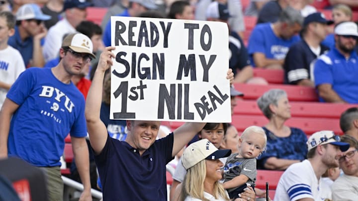 Sep 6, 2024; Dallas, Texas, USA; A view of a fan holding up an NIL sign during the first half of the game between the Southern Methodist Mustangs and the Brigham Young Cougars at Gerald J. Ford Stadium. Mandatory Credit: Jerome Miron-Imagn Images