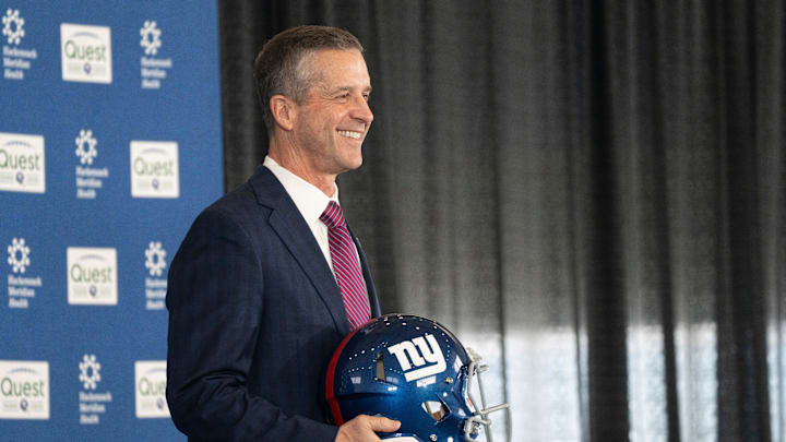 New Giants Head Coach John Harbaugh holds up a New York Giants helmet during a press conference welcoming Harbaugh at the Quest Diagnostics Training Center in East Rutherford on Tuesday, Jan. 20, 2025.
