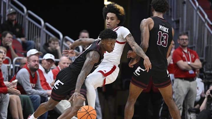 Dec 28, 2024; Louisville, Kentucky, USA;  Eastern Kentucky Colonels guard George Kimble III (left) dribbles the ball against Louisville Cardinals guard Chucky Hepburn (middle) during the second half at KFC Yum! Center. Louisville won 78-76. Mandatory Credit: Jamie Rhodes-Imagn Images