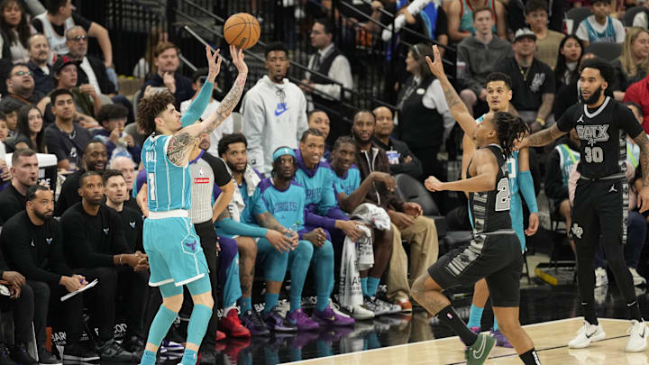 Mar 14, 2025; San Antonio, Texas, USA; Charlotte Hornets guard LaMelo Ball (1) shoots over San Antonio Spurs guard Devin Vassell (24) during the second half at Frost Bank Center. Mandatory Credit: Scott Wachter-Imagn Images
