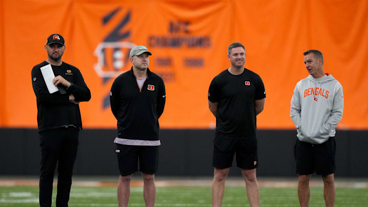 May 12, 2023; Cincinnati, Ohio, USA; Director of college scouting Mike Potts far left) and director of player personnel Duke Tobin (left)  and head coach Zac Taylor (right) and defensive coordinator Lou Anarumo (far right) talk as rookies stretch during rookie mini camp inside the Bengals indoor practice bubble. Mandatory Credit: Kareem Elgazzar/The Cincinnati Enquirer via USA TODAY NETWORK