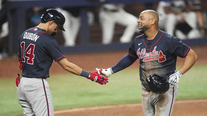 May 20, 2026; Miami, Florida, USA;  Atlanta Braves designated hitter Dominic Smith, right, celebrates scoring a run on a throwing error by Miami Marlins center fielder Esteury Ruiz (not pictured) with shortstop Mauricio Dubon (14) at loanDepot Park. Mandatory Credit: Jim Rassol-Imagn Images