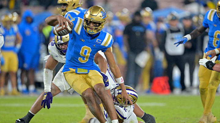 Nov 22, 2025; Pasadena, California, USA;  UCLA Bruins quarterback Nico Iamaleava (9) escapes the grasp of Washington Huskies defensive end Devin Hyde (52) during the second half at the Rose Bowl. Mandatory Credit: Jayne Kamin-Oncea-Imagn Images