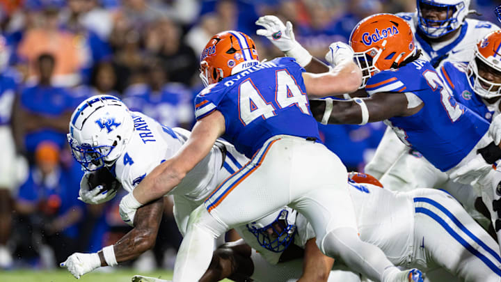 Oct 19, 2024; Gainesville, Florida, USA; Kentucky Wildcats running back Chip Trayanum (4) rushes with the ball while being tackled by Florida Gators defensive end Jack Pyburn (44) during the second half at Ben Hill Griffin Stadium. Mandatory Credit: Matt Pendleton-Imagn Images